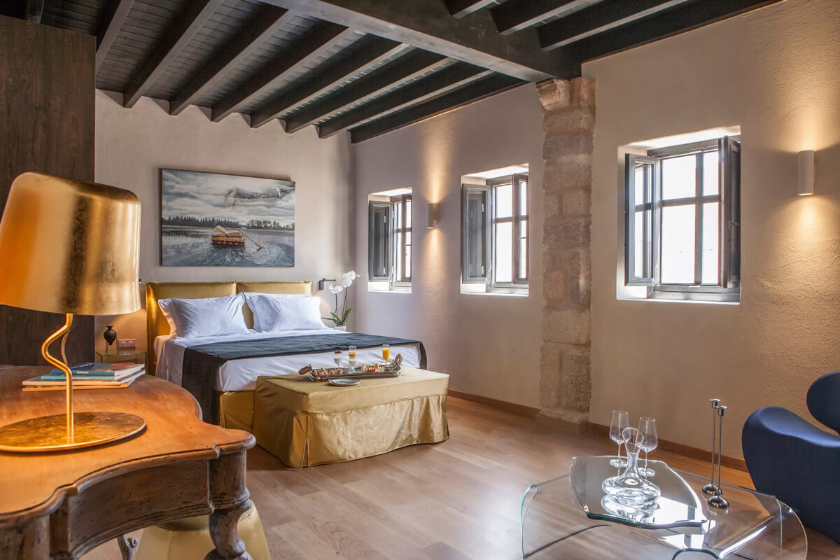 A luxury suite at Allegory Boutique Hotel in Rhodes, Greece, with wooden floors and a bed.