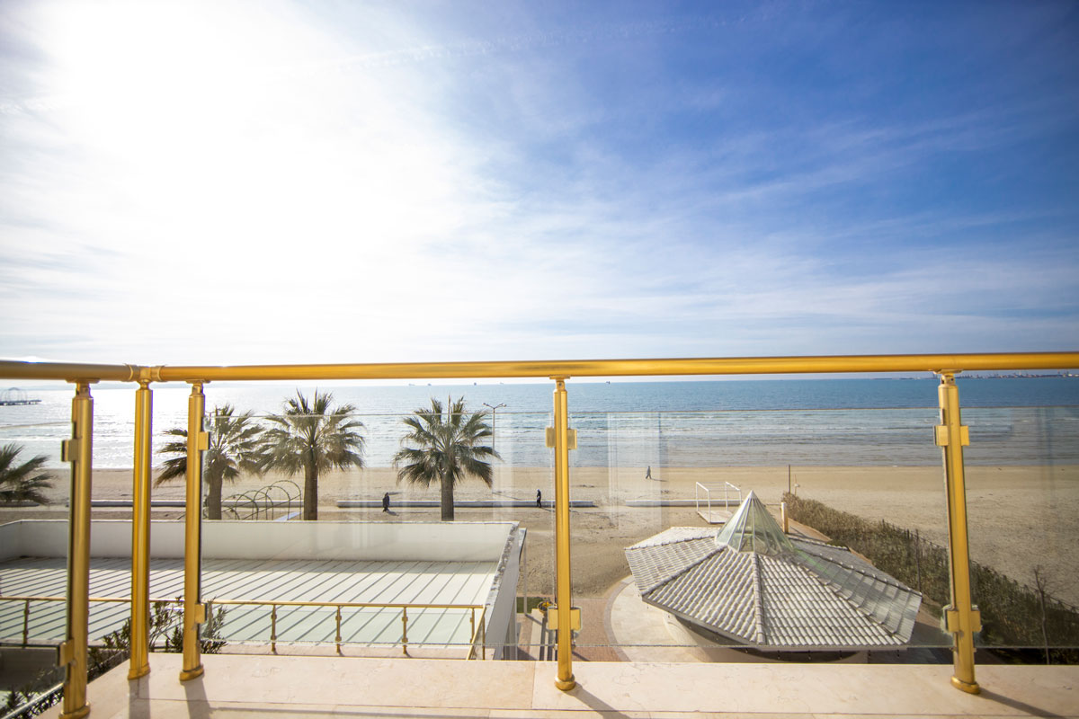 A bedroom with a balcony at Hotel Adriatik, offering a view of the beach and ocean in Durres, Albania