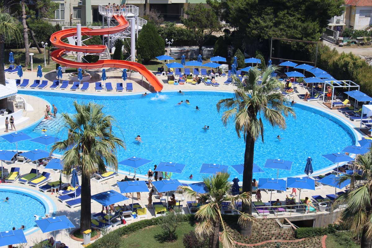 An aerial view of the large outdoor pool with a slide at the Adriatik Hotel in Durres, Albania.