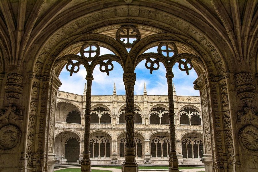 Gothic arches framing the courtyard of a historical cloister, a must-see destination for things to do in Europe over Easter.