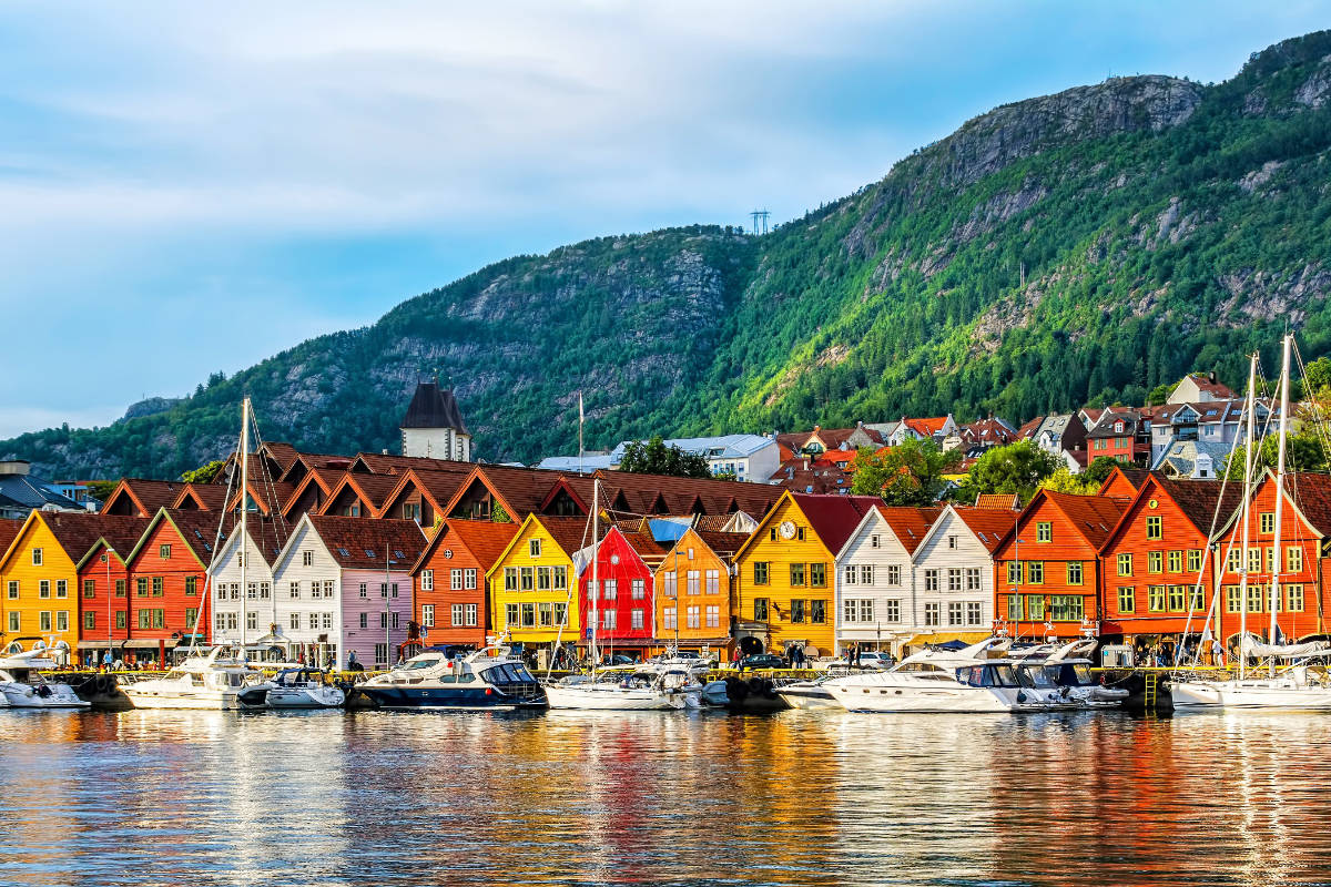 Bryggen in Bergen. Colorful houses along the waterfront with mountains in the background.