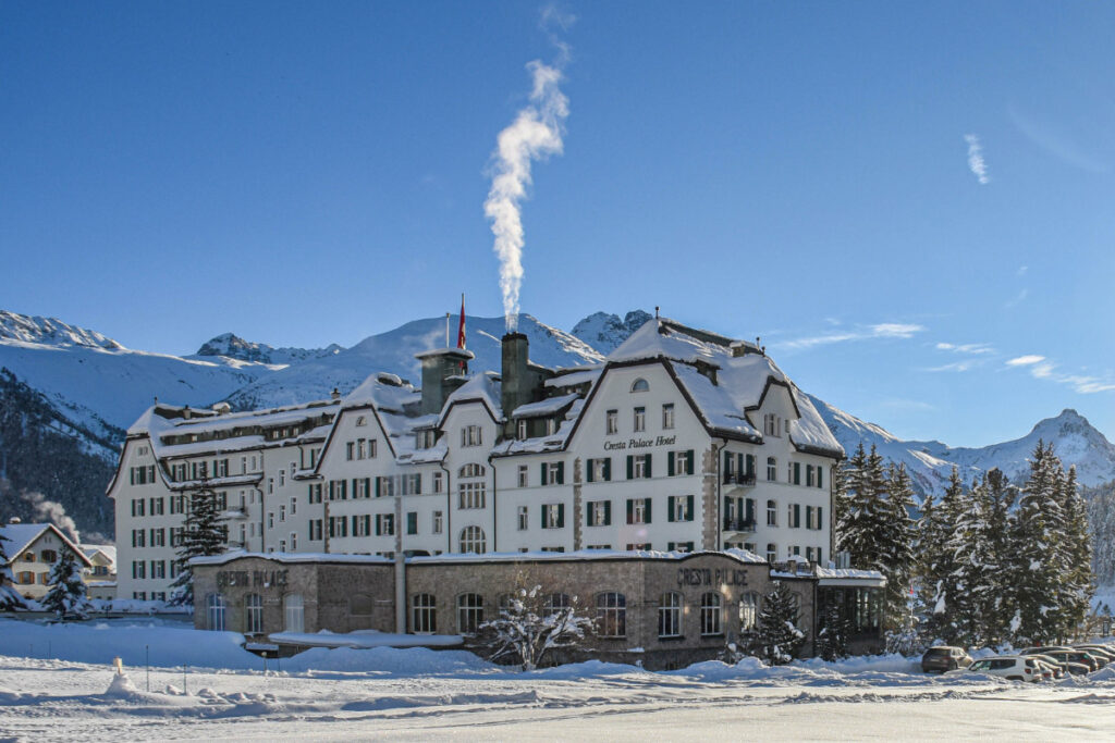 11 Stylish Ski Hotels in Europe 9 Cresta Palace Celerina, Four-star hotel in a snowy landscape with mountains in the background, in Engadin, Switzerland.