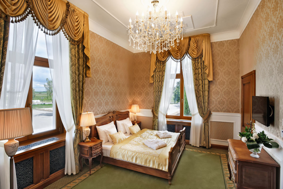 Elegant bedroom at Palace Mortegi SPA hotel in Poland