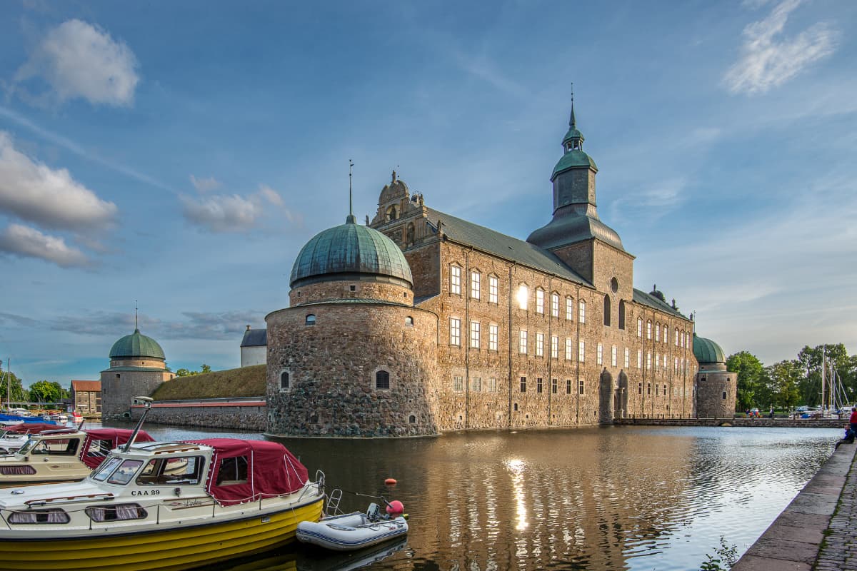 Angedockte Boote an einer ruhigen Uferpromenade neben dem Schloss Vadstena, Schweden